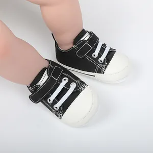 Gros plan sur des chaussures en toile noires pour bébés avec fermeture velcro pratique