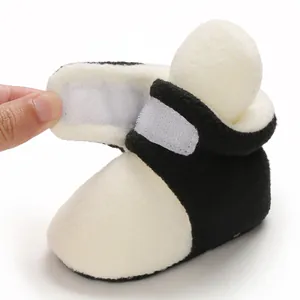 Close-up of soft black and white baby cotton shoe showing Velcro strap closure