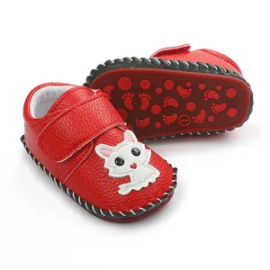 Detailansicht roter handgenähter Babylauflernschuhe mit süßem weißem Kätzchen-Design