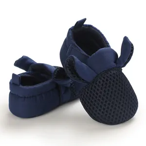 Dettaglio scarpe da passeggio per neonati in rete blu scuro con suole morbide e orecchie