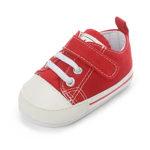 Vue détaillée de la chaussure en toile rouge pour bébé avec lacets blancs et semelle