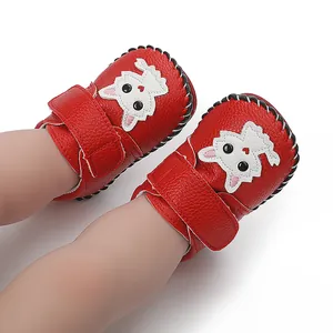 Detailaufnahme der roten Baby-Lernlaufschuhe mit süßem Tiermotiv und Handnähten