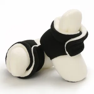 Detailed view of plush black and white baby booties with soft soles for winter