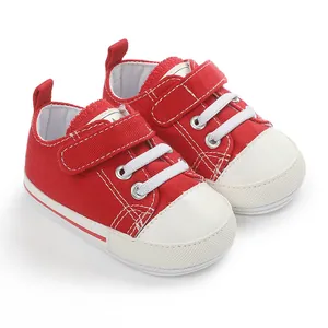 Vue détaillée de chaussures en toile rouge pour bébé avec scratchs et semelle blanche