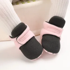 Close-up detail of soft-sole pink and black baby winter shoes with secure Velcro strap.