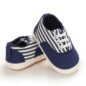 Gros plan de chaussures de marche pour bébé à rayures bleues et blanches avec semelles