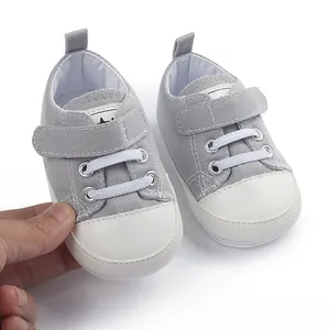 Gros plan de chaussures de marche en toile grise pour bébé avec semelles en caoutchouc blanc