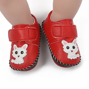 Detailansicht roter Babyschuhe mit Cartoon-Tiermotiv und praktischem Klettverschluss.