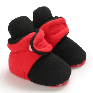 Close-up of baby winter fleece booties in red and black color block with soft sole