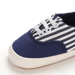 Vue détaillée d'une chaussure pour bébé en toile à rayures bleu marine et semelle souple.