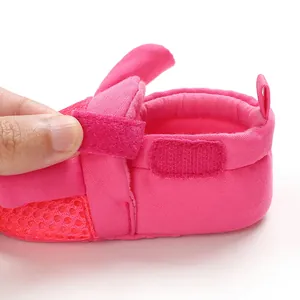 Primo piano della scarpa da passeggio per neonati in rete rosa con chiusura a strappo.
