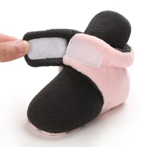 Close-up of pink and black baby fleece bootie with adjustable velcro strap detail
