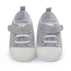 Vue de dessus détaillée chaussures en toile bébé grises avec fermeture velcro et bout blanc