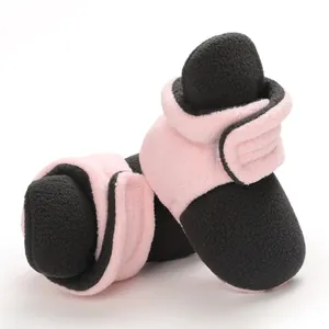 Detailed macro view of soft fleece pink and black baby booties with velcro straps