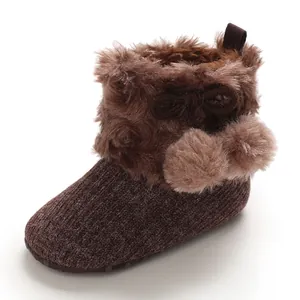 Cozy infant baby girl knit booties with fluffy brown faux fur trim and cute pom-poms