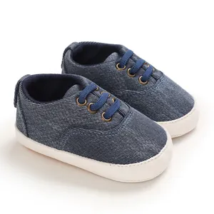 Vue détaillée des chaussures de marche bébé en denim bleu avec semelles souples blanches.