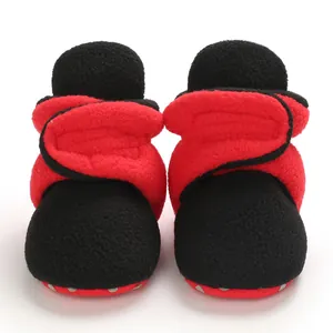 Detailed view of soft red and black fleece baby booties for winter infants 0-1 year old