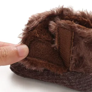 Close-up of brown fuzzy baby bootie with velcro strap detail
