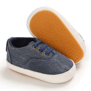 Détail de chaussures de marche bébé en denim avec semelle souple en caoutchouc orange