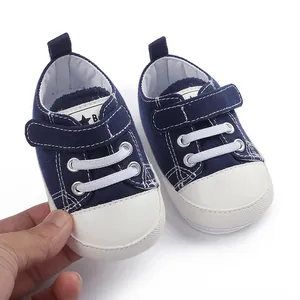 Détail de baskets en toile bleu marine pour bébé avec semelles en caoutchouc et velcro.