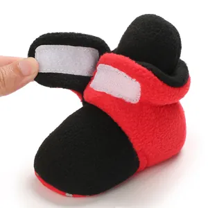 Close-up of the hook-and-loop fastener on soft red and black baby fleece boots
