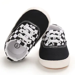 Détail de chaussures de marche pour bébé en toile à carreaux noirs et blancs