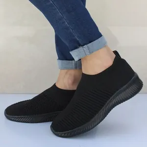 Detailopname van zwarte ademende gebreide instapsneakers voor dames op de voet getoond