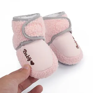 Close-up of pink fleece baby winter boots featuring heart embroidery detail and soft texture.