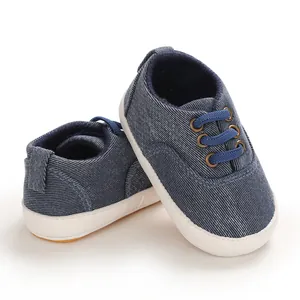 Vue de côté de chaussures de marche pour bébé en jean bleu marine avec semelle souple