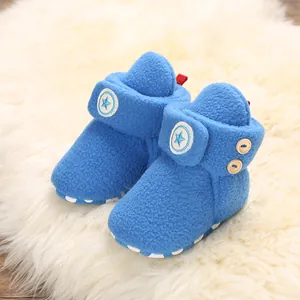 Dettaglio stivaletti neonato in pile blu con logo a stella e bottoni in legno
