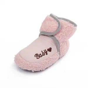 Macro view of pink sherpa baby winter bootie featuring heart embroidery and soft lining.