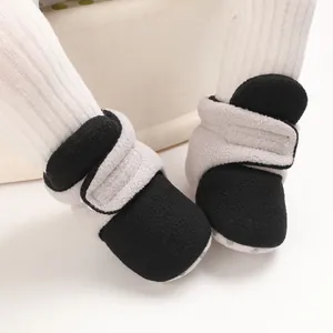 Close-up of baby fleece cotton shoes with soft soles in black and grey color blocking.