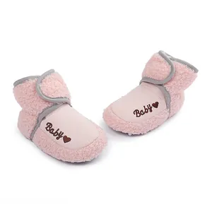 Close-up of pink baby winter booties with soft fleece and Baby heart embroidery