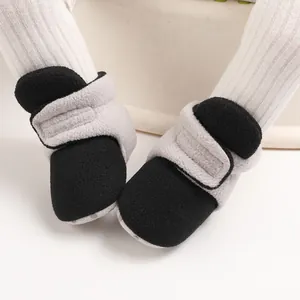 Close-up view of soft-soled black and grey baby cotton booties with velcro strap for infants.