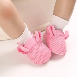 Dettaglio di scarpe in rete rosa per neonati con orecchie di coniglio e suola morbida.