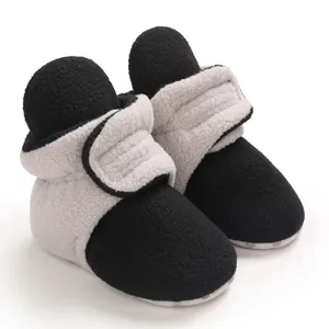 Detailed macro view of soft fleece baby booties with adjustable grey hook and loop closure