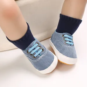 Détail de chaussures de marche pour bébé en denim bleu avec semelles en gomme.