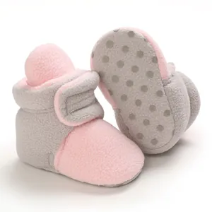 Detailed view of pink and grey soft sole baby fleece booties showing anti-slip dots