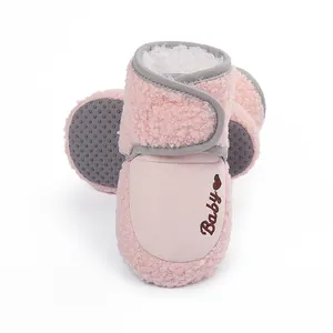 Detailed macro view of soft pink fleece baby winter boots with cute heart embroidery details