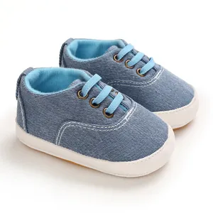 Gros plan sur des chaussures de marche pour bébé en jean bleu avec semelles blanches