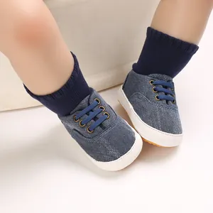 Gros plan de chaussures de marche pour bébé en denim bleu avec semelles en caoutchouc blanc