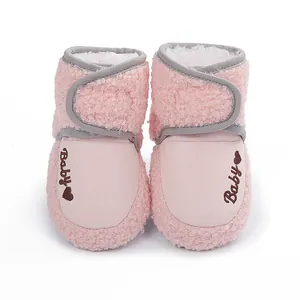 Detailed view of pink fuzzy baby walker boots with embroidered Baby text and heart icon
