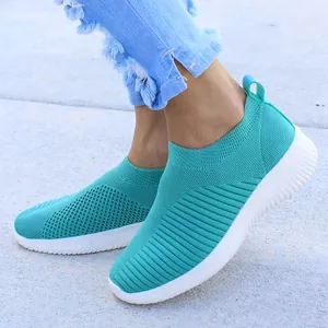 Levendige turquoise ademende mesh slip-on sneakers voor dames op grijs trottoir