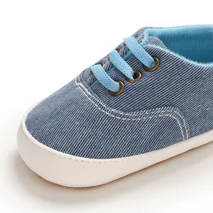 Gros plan sur des chaussures de marche pour bébé en denim bleu avec semelle en caoutchouc.
