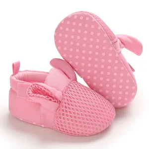 Primo piano scarpe neonato in mesh rosa con suola morbida e orecchie da coniglio