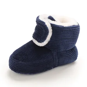 Detail of warm baby snow boots with blue corduroy and white fleece lining.