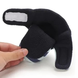 Makroansicht des warmen Fleece-Futters und des Klettverschlusses am gestreiften Babyschuh