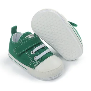 Vue détaillée de chaussure bébé en toile verte avec semelle gomme et scratch