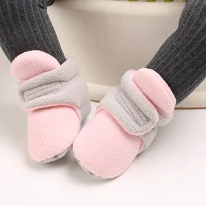 Close-up of pink and grey soft-soled baby cotton shoes with velcro straps for infants.