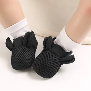 Scarpe primi passi in rete nera per neonati con graziose orecchie da coniglio.